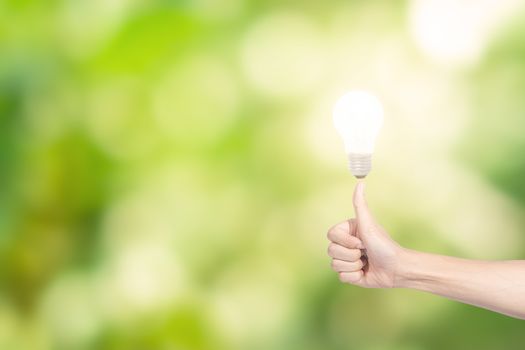 Human hand concept, saving energy from light bulbs, natural bokeh background