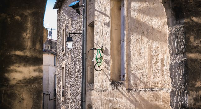 Montpellier, France - January 2, 2019: child's bike hanging on a wall in the historic city center by an anonymous artist with the pseudonym BMX