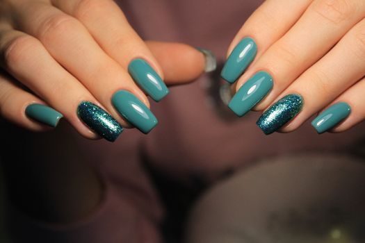 Closeup photo of a beautiful female hands with elegant manicure and diamond rings.