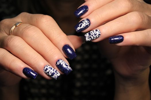 Closeup photo of a beautiful female hands with elegant manicure and diamond rings.