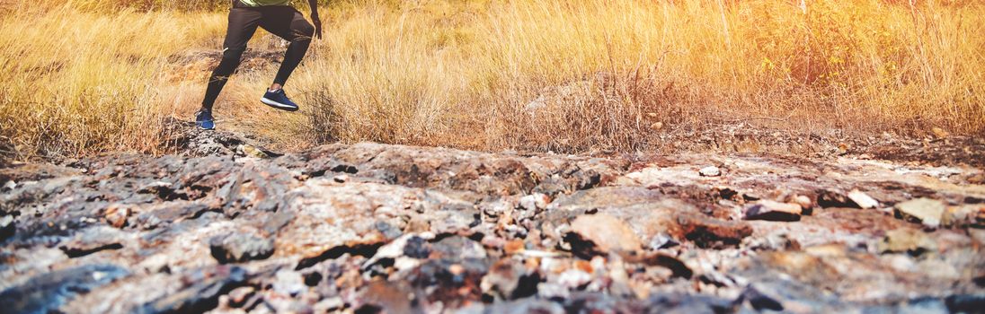 Legs of African Man running on mountain trail. Panoramic, Banner, Meadow, Dry, Grass, Nature.