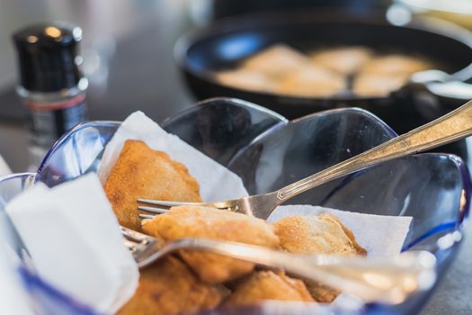 fried portuguese or brazilian rissoles in a pan in a kitchen