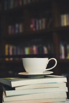 Coffee cup and stack of books on wood table. Education concept.