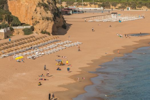 Albufeira, Portugal - May 3, 2018: High view of the city beaches in a very tourist destination in southern Portugal, in the Algarve where people are resting on a spring day