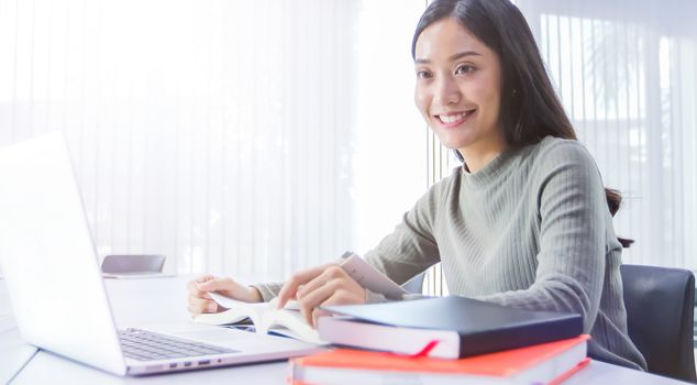 Asian students use notebook and tablet computers to work and study online at home during the coronavirus epidemic and quarantine at home