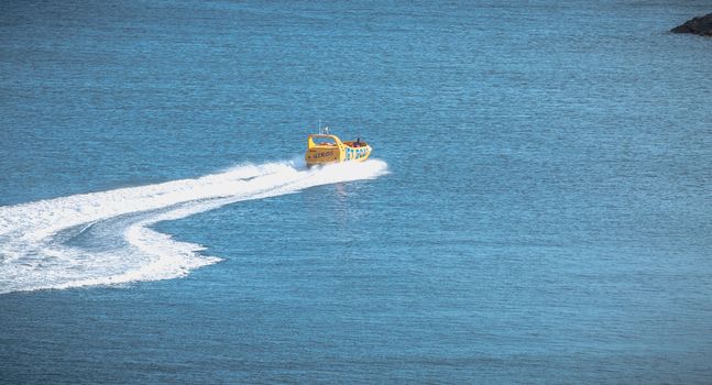 Albufeira, Portugal - May 3, 2018: Jetboat for tourists entering the harbor at full speed on a spring day