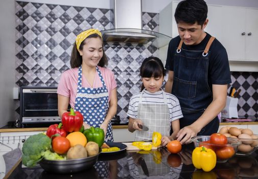 Asian families are cooking  and parents are teaching their daughters to cook in the kitchen at home. 
Family activities on holidays and Happy in recreation concept