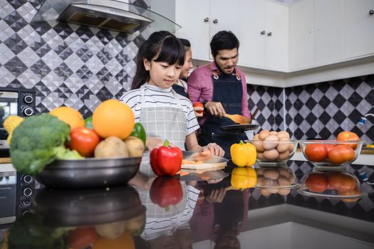 Asian families are cooking  and parents are teaching their daughters to cook in the kitchen at home. 
Family activities on holidays and Happy in recreation concept