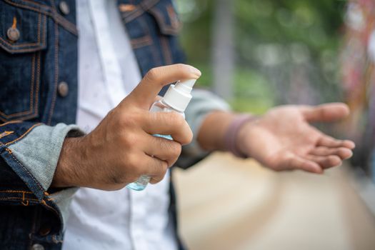 Asian men using Alcohol spray and Alcohol gel or lotion for dealing with flu and virus prevention on hand