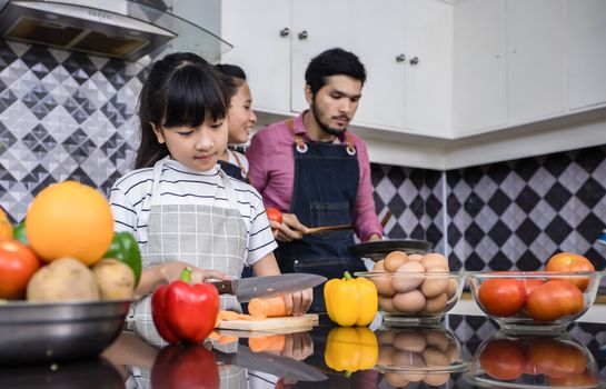 Asian families are cooking  and parents are teaching their daughters to cook in the kitchen at home. 
Family activities on holidays and Happy in recreation concept