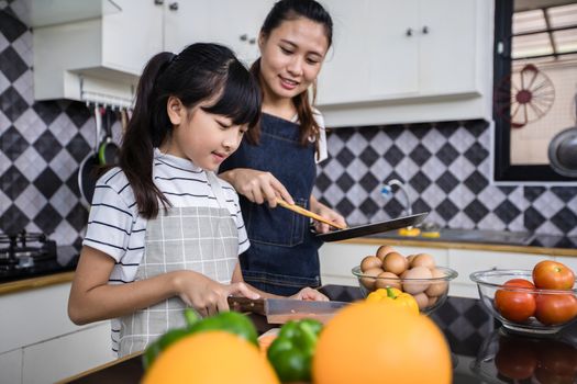 Asian families are cooking  and parents are teaching their daughters to cook in the kitchen at home. 
Family activities on holidays and Happy in recreation concept