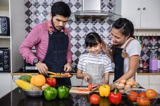 Asian families are cooking  and parents are teaching their daughters to cook in the kitchen at home. 
Family activities on holidays and Happy in recreation concept