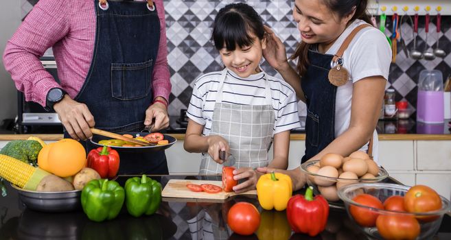 Asian families are cooking  and parents are teaching their daughters to cook in the kitchen at home. 
Family activities on holidays and Happy in recreation concept