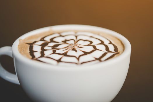 A cup of coffee on wooden table in cafe.