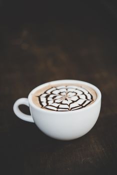 A cup of coffee on wooden table in cafe.