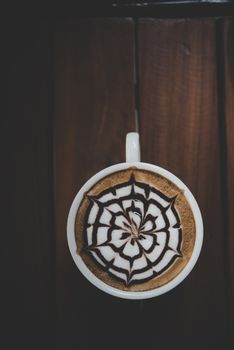 A cup of coffee on wooden table in cafe.