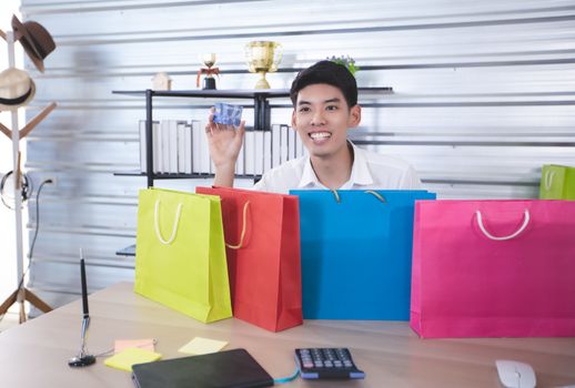 Asian man blogger broadcasting a video for selling product online such as Hats, shoes, headphones, clothing, safety headers.Shopping online concept  at home