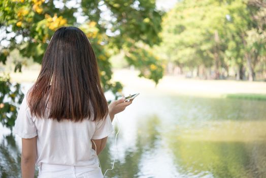 Rear of young woman relaxing at park.