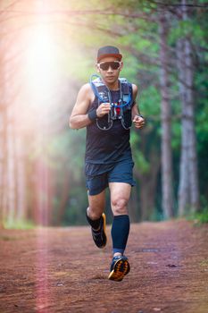 A man Runner of Trail and athlete's feet wearing sports shoes for trail running in the forest