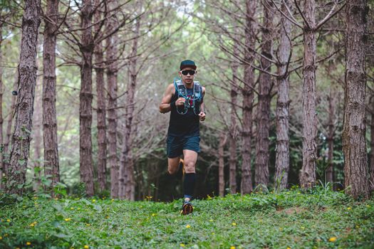 A man Runner of Trail and athlete's feet wearing sports shoes for trail running in the forest