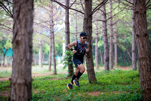 A man Runner of Trail and athlete's feet wearing sports shoes for trail running in the forest