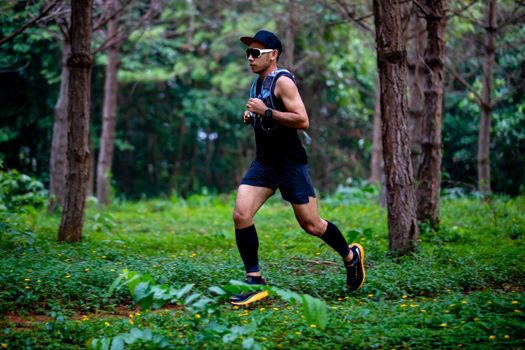 A man Runner of Trail and athlete's feet wearing sports shoes for trail running in the forest