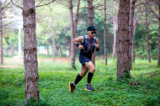 A man Runner of Trail and athlete's feet wearing sports shoes for trail running in the forest