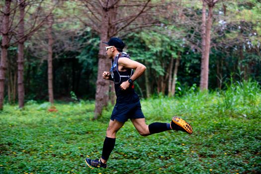 A man Runner of Trail and athlete's feet wearing sports shoes for trail running in the forest