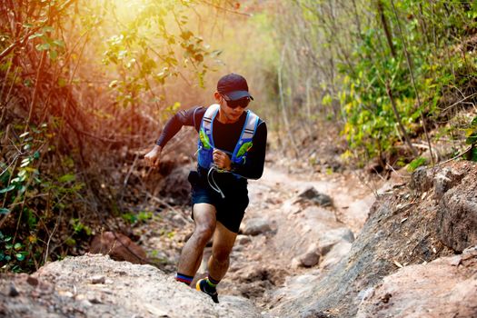 A man Runner of Trail and athlete's feet wearing sports shoes for trail running in the forest