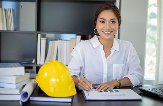 Beautiful Asian engineering women checking document and using notebook working from home for social distance and self responsibility concept