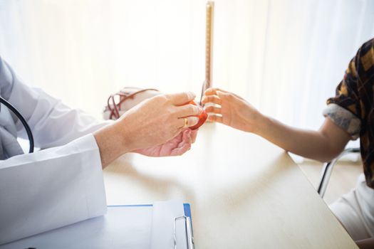 The doctor is asking and explaining the illness and giving the medicine. With female patients in his office at the hospital.