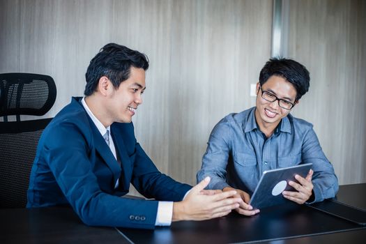 Asian businessmen and group using notebook for business partners discussing documents and ideas at meeting and business women smiling happy for working