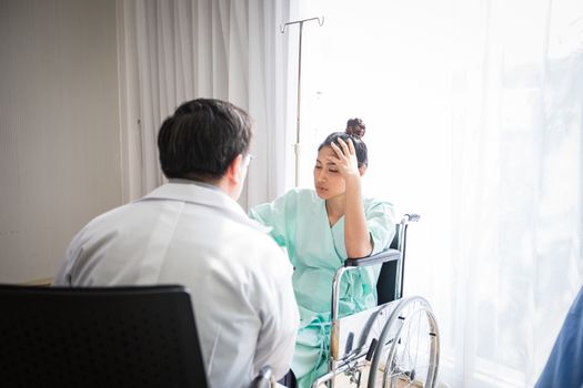 The doctors are asking and explaining about the illness to a female patient lying in bed at a hospital.