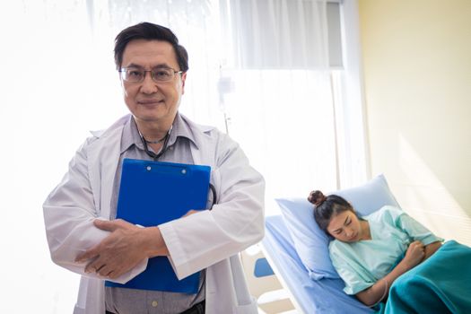 The doctors are asking and explaining about the illness to a female patient lying in bed at a hospital.