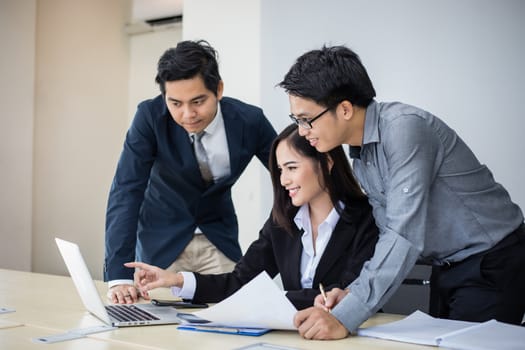 Asian businessmen and group using notebook for business partners discussing documents and ideas at meeting and business women smiling happy for working