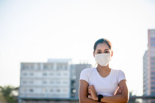 Asian Young fitness sport woman running  and she wears a mask for protective Dust and pollution and protection flu virus, influenza, coronavirus on city