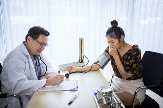 Doctor meeting and explaining medication to woman patient in his office at Hospitals