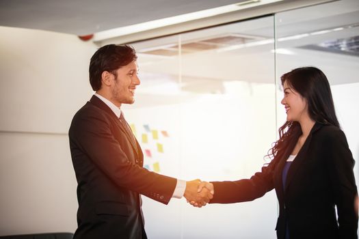 Business people shaking hands and smiling their agreement to sign contract and finishing up a meeting