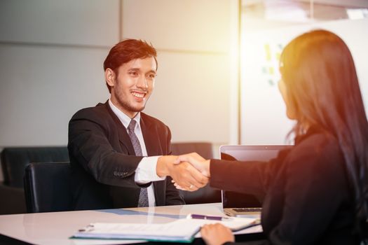 Business people shaking hands and smiling their agreement to sign contract and finishing up a meeting