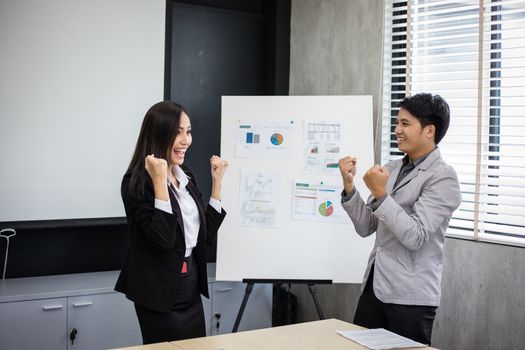 Asian businessmen and businesswomen Success and winning concept - happy team with raised up hands celebrating the breakthrough and achievements