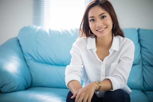 Asian women sitting relaxation on sofa and she is smiling happy at home