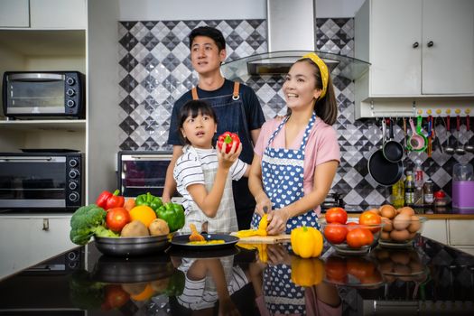 Happy Family have Dad, Mom and their little daughter Cooking Together in the Kitchen