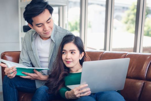 Portrait of Couple Love Relaxing and Enjoying Together in Their Home, Romantic Asian Couple Relax Resting on Comfortable Couch in Living Room. Leisure Activity and Lifestyles Concept