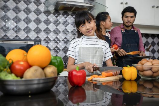 Happy Family have Dad, Mom and their little daughter Cooking Together in the Kitchen