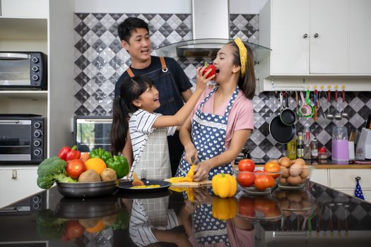 Happy Family have Dad, Mom and their little daughter Cooking Together in the Kitchen