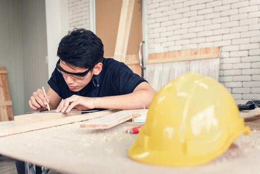 Carpenter Man is Working Timber Woodworking in Carpentry Shophouse, Craftsman is Measuring Timber Frame for Wooden Furniture in Workshop. Workmanship and Job Occupation Concept