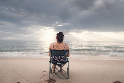 Freelancer Woman is Working on Tablet While Travel Vacation Trip at The Beach, Smart Woman is Using Tablet for Communication and Entertainment at Outdoor Sand Beach. Freelance and Relaxation Concept.