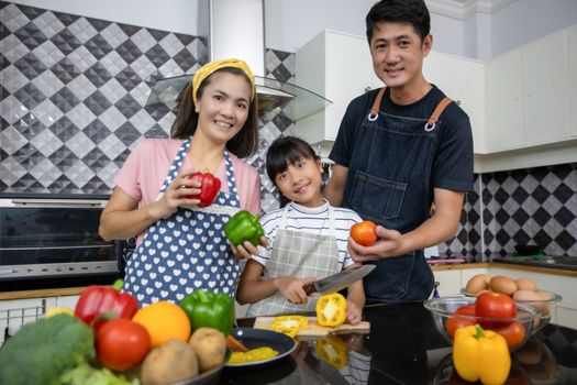 Happy Family have Dad, Mom and their little daughter Cooking Together in the Kitchen