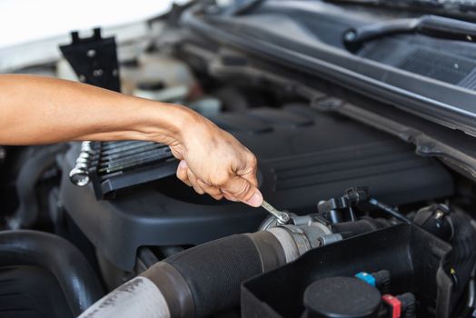 Mechanic Car Service Man is Working in Garage Workshop, Close-Up of Technician Automotive Hand is Inspection Checking and Repairing Mechanical Car Engine. Auto Services and Maintenance Concept