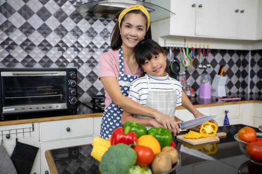 Happy Family have Dad, Mom and their little daughter Cooking Together in the Kitchen